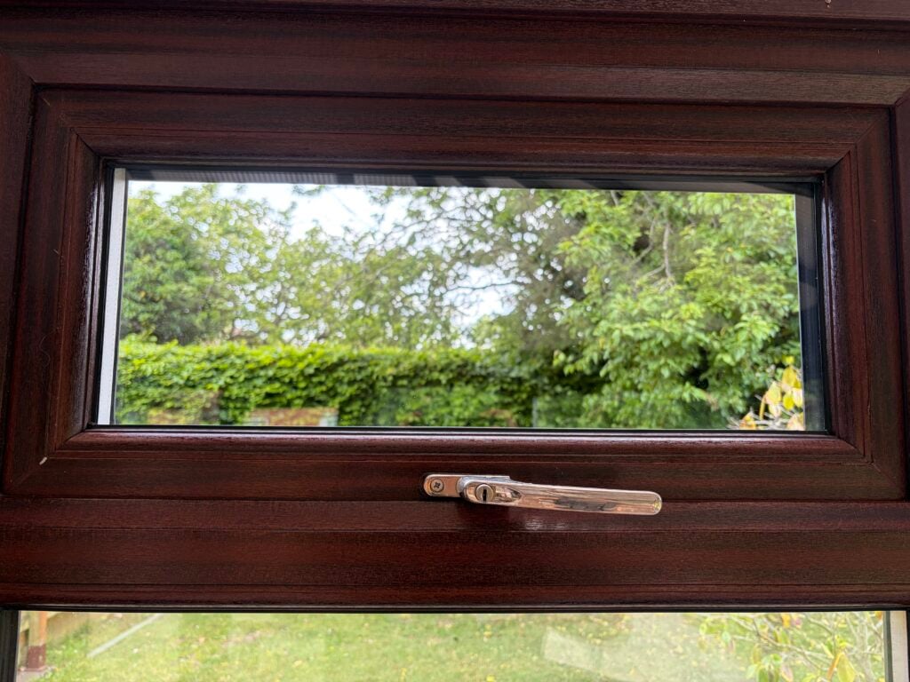 Clear glass in a woodgrain casement window overlooking a garden