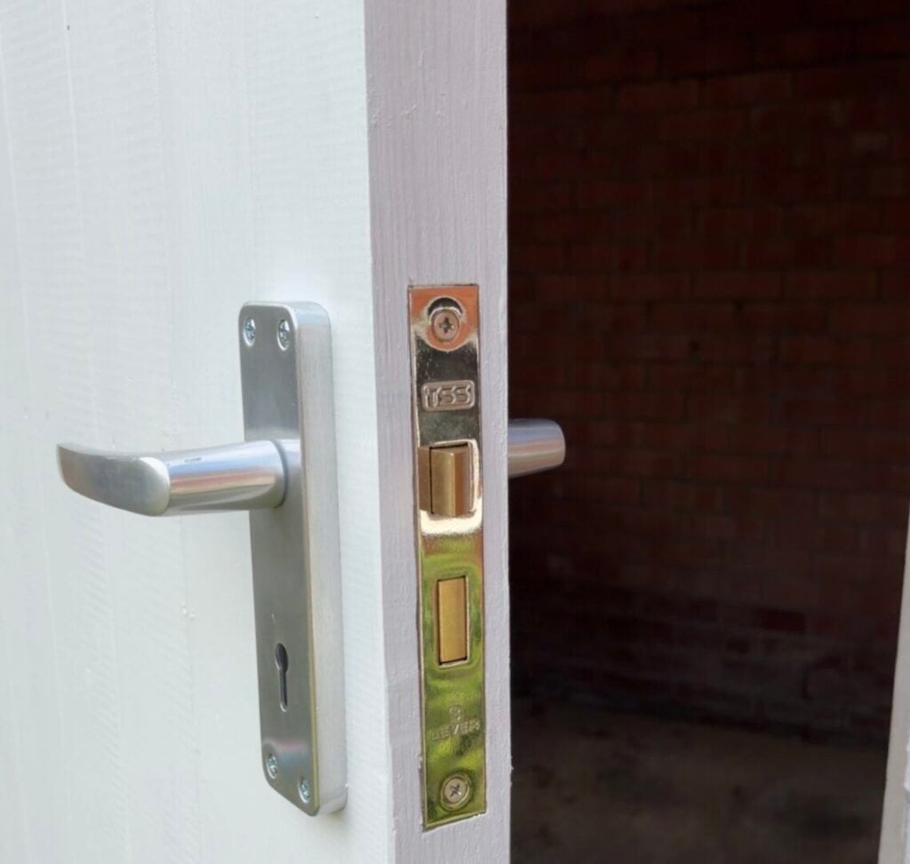 Silver lever handle and mortice lock fitted to a white painted door
