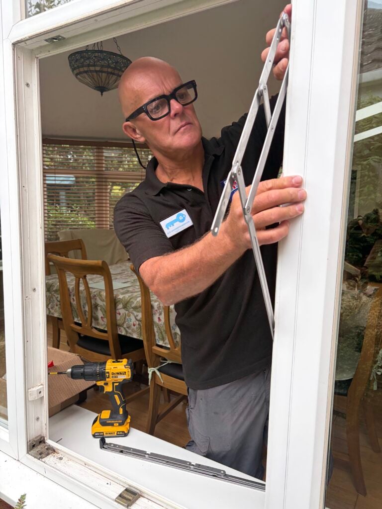 BC Locksmith technician working on a white UPVC window hinge