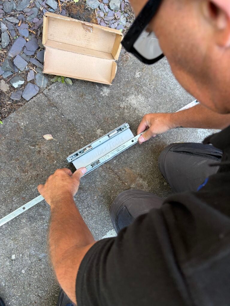 Locksmith inspecting a multipoint door lock mechanism removed from a door
